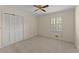 This bedroom features white closet doors, a window with blinds, and neutral colored walls and carpet at 3770 Clubland Trl, Marietta, GA 30068