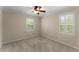 This bedroom features two windows with blinds providing natural light, and neutral colored walls and carpet at 3770 Clubland Trl, Marietta, GA 30068