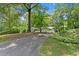 View of the long driveway leading to a well-maintained home nestled among mature trees at 3770 Clubland Trl, Marietta, GA 30068