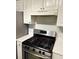 Stainless steel stove and white tile backsplash with white cabinets above and to the side at 320 Orleans Blvd, Mcdonough, GA 30253
