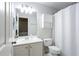 Well-lit bathroom with a mirror, vanity, toilet, and a shower with a white curtain at 4766 Longcourt Se Dr # 23, Atlanta, GA 30339