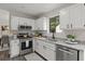 Bright kitchen showcasing stainless steel appliances, granite counters, and white cabinets at 4912 Bayside Ct, Stone Mountain, GA 30088