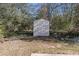 Backyard featuring a white storage shed offering practical outdoor solutions, with mature trees offering shade and privacy at 4912 Bayside Ct, Stone Mountain, GA 30088