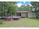 Charming backyard features a large wooden deck, lush lawn, and mature trees at 510 Pineland Sw Rd, Mableton, GA 30126