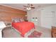 Bedroom features a red bedspread, carpeted floors, wood accent wall and a ceiling fan at 510 Pineland Sw Rd, Mableton, GA 30126