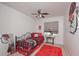 Sports themed bedroom has a ceiling fan, window, bedside table, and decorative bulldog artwork at 510 Pineland Sw Rd, Mableton, GA 30126