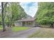 View of the home with a driveway and fenced in yard, showing it sits within a wooded area at 510 Pineland Sw Rd, Mableton, GA 30126
