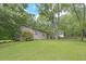 Side view of the tan siding of the home, set on a lush green lawn with trees and shrubbery at 510 Pineland Sw Rd, Mableton, GA 30126