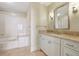 Bright bathroom with a large vanity with granite countertops and a shower and tub combo at 2700 Paces Ferry Se Rd # 202, Atlanta, GA 30339