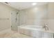 Luxurious bathroom featuring a soaking tub, glass-enclosed shower, and tiled walls at 2700 Paces Ferry Se Rd # 202, Atlanta, GA 30339