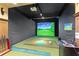 This room features a golf simulator with a projector screen, golf clubs, and other accessories at 2700 Paces Ferry Se Rd # 202, Atlanta, GA 30339