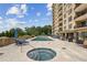 Upscale pool area featuring a hot tub, sun loungers, and manicured landscaping against a backdrop of the high-rise building at 2700 Paces Ferry Se Rd # 202, Atlanta, GA 30339