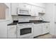 Efficient galley kitchen with white cabinets, white appliances and dark countertop at 3142 Reeves Se St, Smyrna, GA 30080