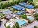Aerial view of the community pools, tennis courts, and clubhouse amidst mature trees at 413 Sassafras Rd, Roswell, GA 30076