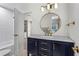 Bathroom featuring a modern vanity with marble countertop, gold hardware, and access to the shower and bedroom at 413 Sassafras Rd, Roswell, GA 30076
