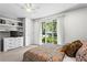 Bright bedroom featuring built-in shelves, dresser, and natural light from the sliding glass door overlooking the yard at 413 Sassafras Rd, Roswell, GA 30076
