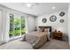 Cozy bedroom with natural light, ceiling fan, and views of the lush yard at 413 Sassafras Rd, Roswell, GA 30076