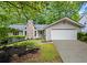 Charming home featuring a stone chimney, well-manicured lawn, and attached two-car garage at 413 Sassafras Rd, Roswell, GA 30076