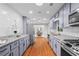 Open kitchen with stainless steel appliances, granite countertops, and hardwood flooring at 413 Sassafras Rd, Roswell, GA 30076