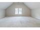 Carpeted bonus room under vaulted ceiling with window at 5335 Lexington View Pl, Sugar Hill, GA 30518