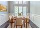 Dining room with seating for six, wood flooring, and natural light from a large window at 5335 Lexington View Pl, Sugar Hill, GA 30518