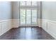 Bright dining room featuring wood floors, large windows, and classic wainscoting at 5335 Lexington View Pl, Sugar Hill, GA 30518