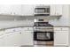 Kitchen displays white cabinetry, granite countertops, and stainless steel appliances at 5335 Lexington View Pl, Sugar Hill, GA 30518