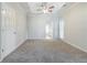 Carpeted primary bedroom featuring tray ceiling with fan, and bath access at 5335 Lexington View Pl, Sugar Hill, GA 30518