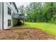 Backyard features grass, trees and the back of a two-story brick house with an elevated deck at 5380 Northchester Ct, Dunwoody, GA 30338