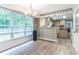 Bright dining area with large windows and wood floors adjacent to the kitchen with pendant lighting at 5380 Northchester Ct, Dunwoody, GA 30338