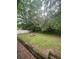 Spacious backyard with green grass, stone table and benches, and a wooden fence at 6860 Parkway Dr, Lithonia, GA 30058