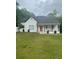 Attractive home featuring a classic front porch, neat landscaping, and a vibrant red door at 6860 Parkway Dr, Lithonia, GA 30058