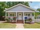 Charming bungalow features a covered front porch with rose bushes and a freshly painted exterior at 789 Third St, Stone Mountain, GA 30083
