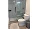 Modern bathroom features a glass-enclosed shower with gray tiles, a white toilet, and stylish accents at 1280 W Peachtree Nw St # 2409, Atlanta, GA 30309