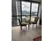 A sunlit living room corner with two chairs offering views of the city skyline at 1280 W Peachtree Nw St # 2409, Atlanta, GA 30309