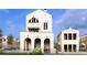 Charming new construction home featuring a white brick exterior, arched entry, and a stylish second-story balcony at 215 Rolison Way, Fayetteville, GA 30214