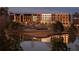 Dusk view of modern hotel with mix of brick, white, and grey façade and lakeside view at 215 Rolison Way, Fayetteville, GA 30214