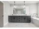 Elegant bathroom featuring double sink vanity, marble floors, modern fixtures, and a soaking tub at 481 Saddle Ridge Dr, Lawrenceville, GA 30046