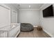 Bright Bedroom featuring a white crib, beanbag chair, wood floors, and a wall mounted television at 481 Saddle Ridge Dr, Lawrenceville, GA 30046