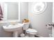 Cozy half-bath features a pedestal sink and decorative lighting fixture for a modern look at 58 Parkside Cir, Marietta, GA 30068