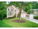 Charming two-story home with a well-manicured lawn, mature trees, and a convenient PODS moving container at 58 Parkside Cir, Marietta, GA 30068