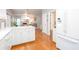 Open kitchen with white cabinets, hardwood floors, and a view into the adjacent living spaces at 58 Parkside Cir, Marietta, GA 30068