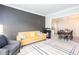 Open-concept living room featuring a stylish grey accent wall, modern furniture, and adjacent dining area at 58 Parkside Cir, Marietta, GA 30068