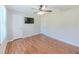 Bedroom with hardwood floors, featuring a ceiling fan and wall-mounted TV at 70 Heritage Way, Covington, GA 30016