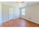 Bedroom with ceiling fan, wood-look flooring, and natural light from the window at 70 Heritage Way, Covington, GA 30016
