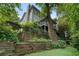 Backyard shows lush landscaping, stone steps, mature trees, and screened-in porch at 1066 High Point Ne Dr, Atlanta, GA 30306
