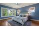 Charming bedroom with beautiful blue walls and large windows offering serene wooded views at 1066 High Point Ne Dr, Atlanta, GA 30306