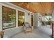 Inviting front porch with wicker furniture, beautiful wood ceiling, and views of a lush landscape at 1066 High Point Ne Dr, Atlanta, GA 30306