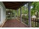 View of a covered porch with wood decking, a wood railing and supports, and foliage in the background at 1066 High Point Ne Dr, Atlanta, GA 30306