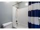 Clean and modern shower with white subway tile and a blue striped shower curtain at 1066 High Point Ne Dr, Atlanta, GA 30306